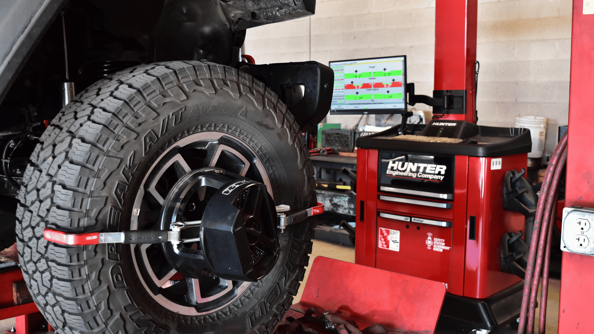 Wheel alignment equipment attached to a vehicle tire during a steering and suspension inspection
