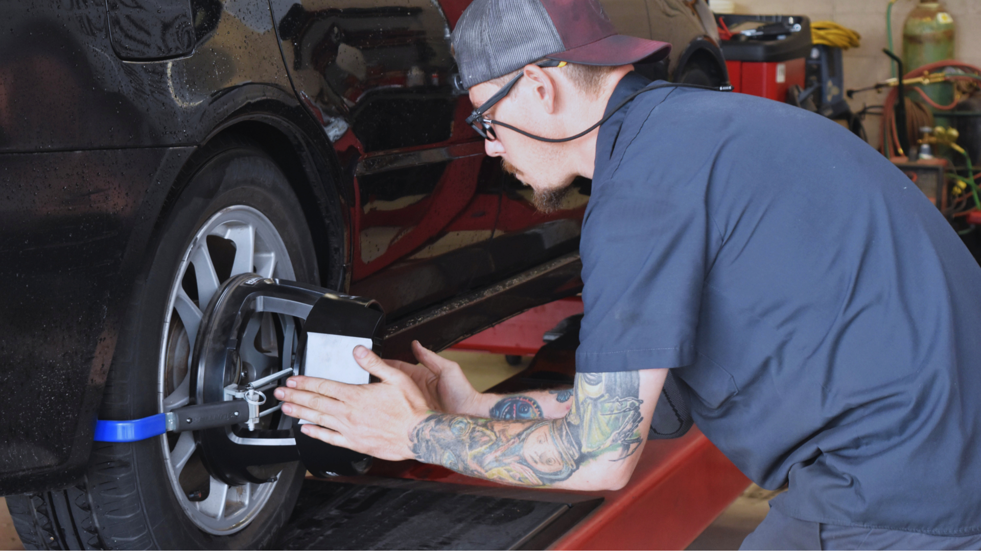 Precision Tire employee performing wheel alignment service at North Phoenix tire shop