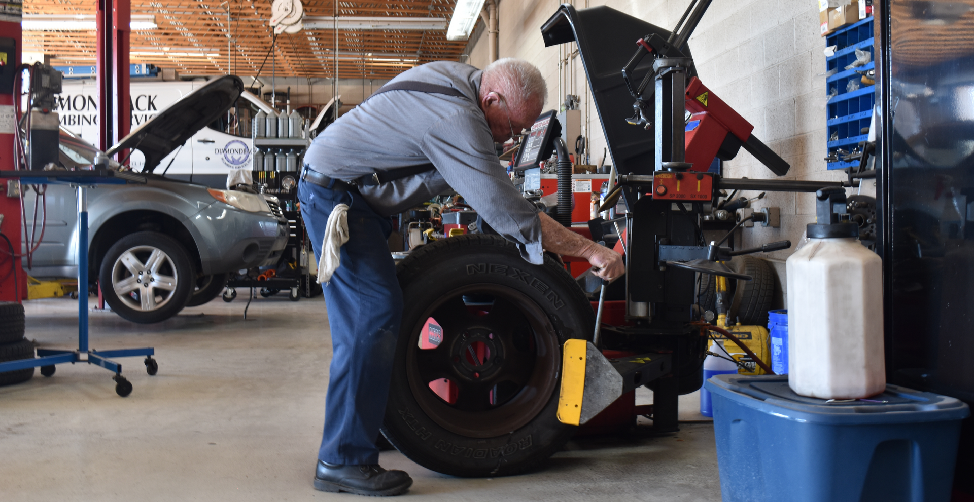Precision Tire employee working at North Phoenix tire shop, replacing an old tire with a new one