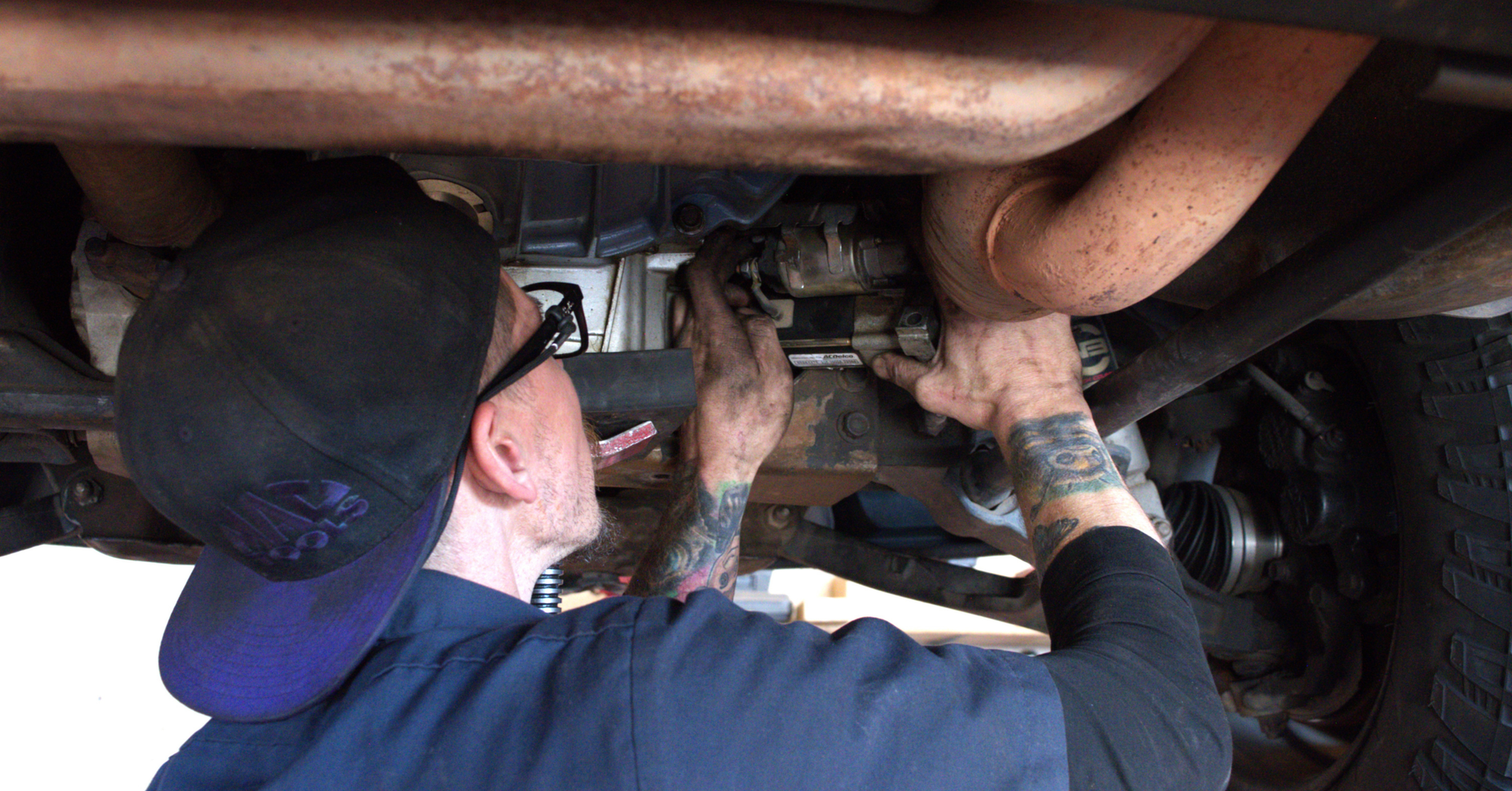 Precision technician replacing a car starter in Phoenix to fix no start condition caused by heat