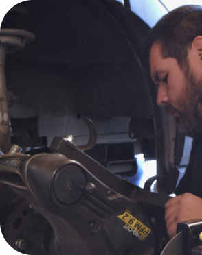 mechanic working on exhaust | Precision Tire and Auto Center