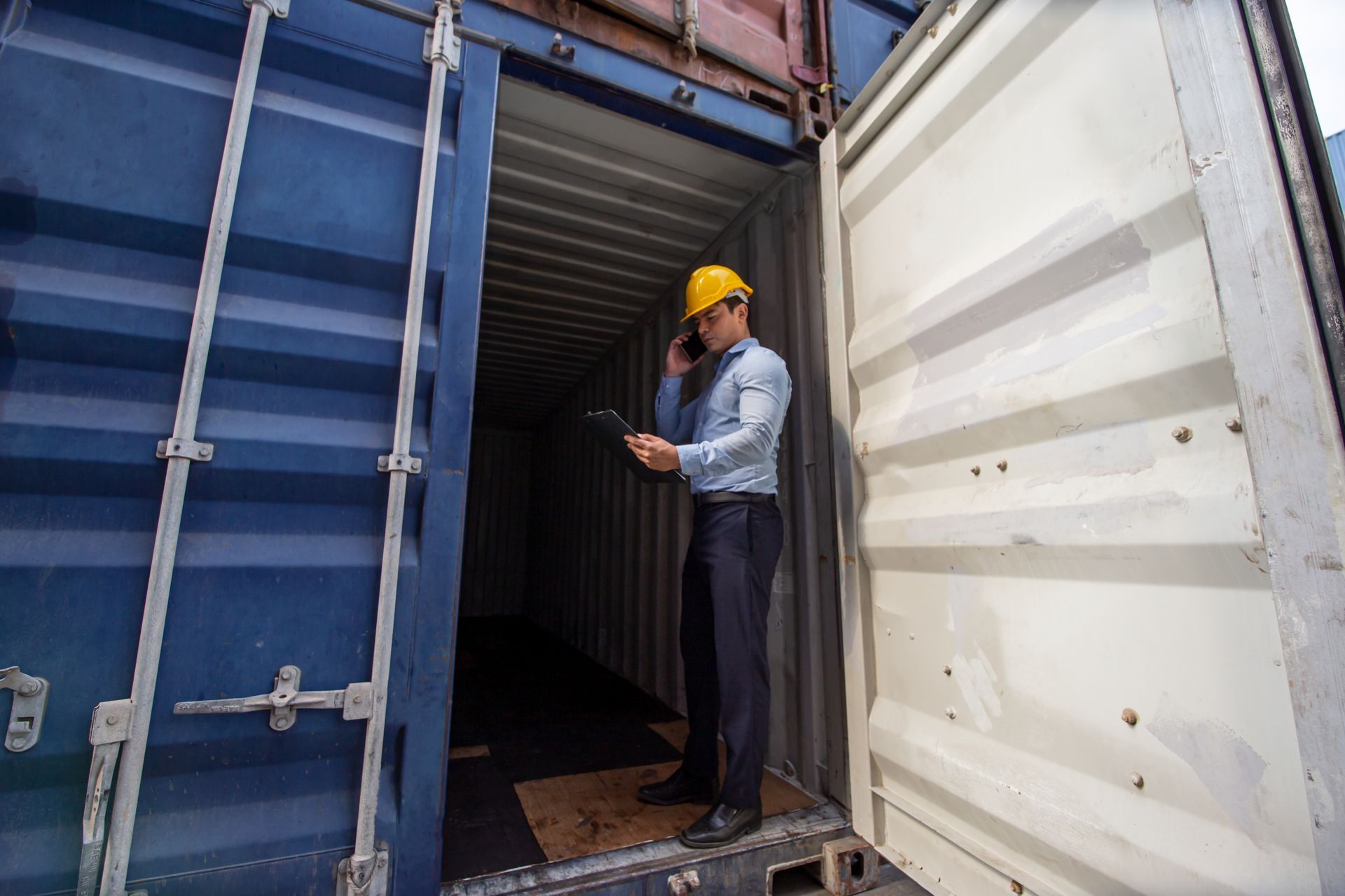 Professional inspector examining shipping container interior for cargo-worthy certification