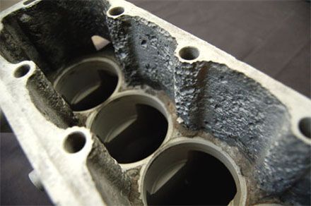 Culata de motor con picaduras y erosión severas.