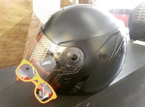 casco per la motocicletta e un paio di occhiali da sole con montatura gialla