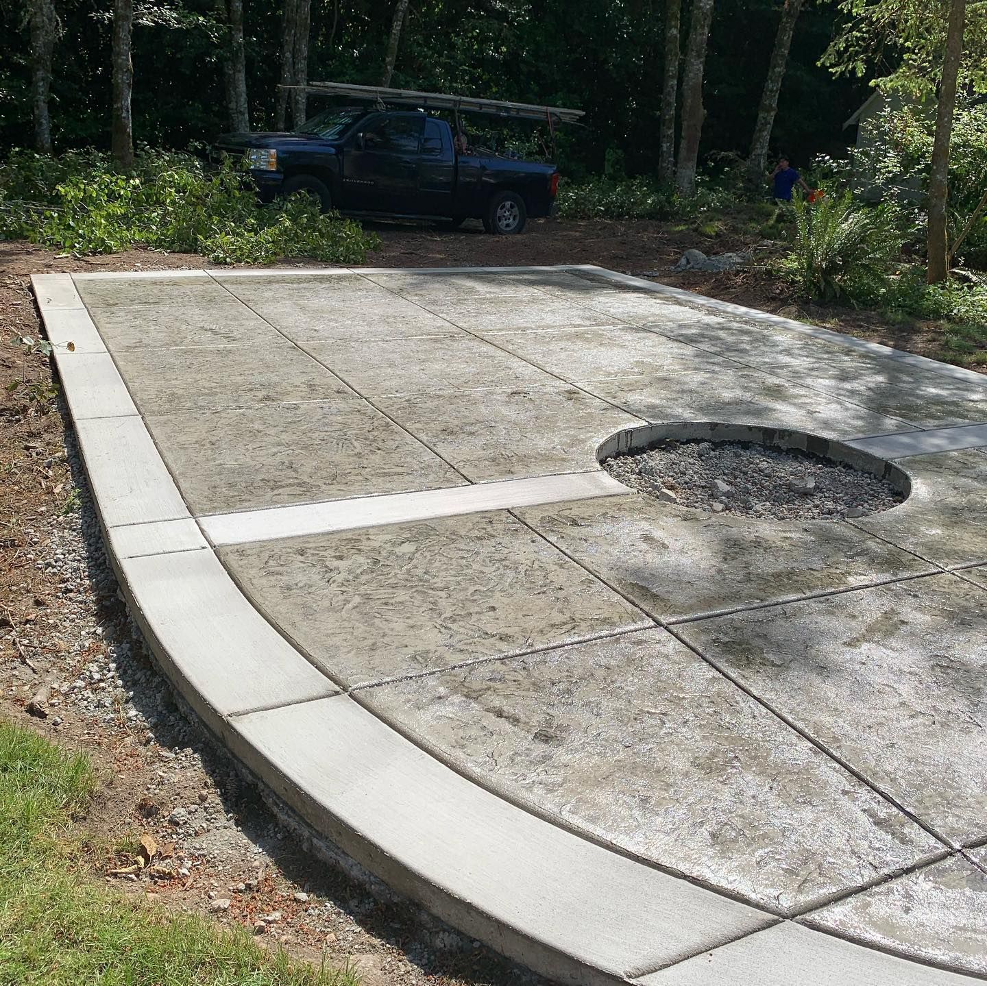 A truck is parked on the side of a concrete driveway