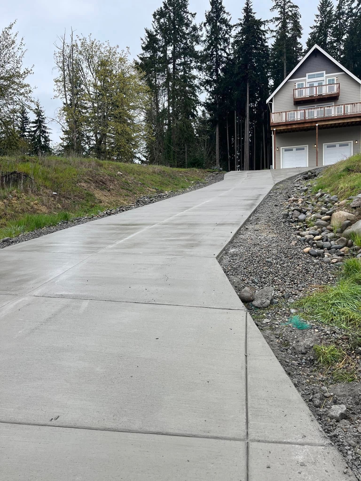 A concrete driveway with a house in the background