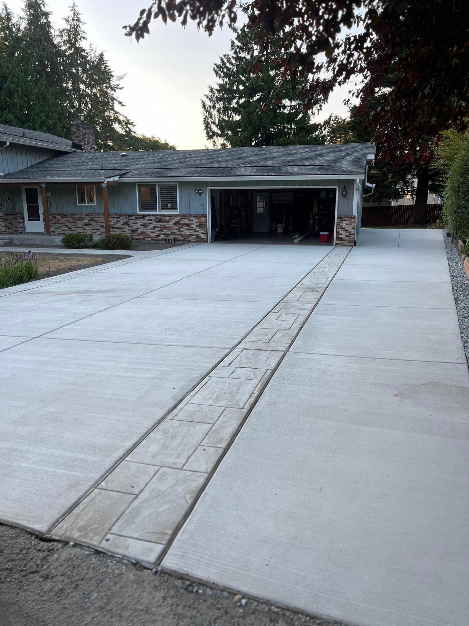 A concrete driveway leading to a house with a garage