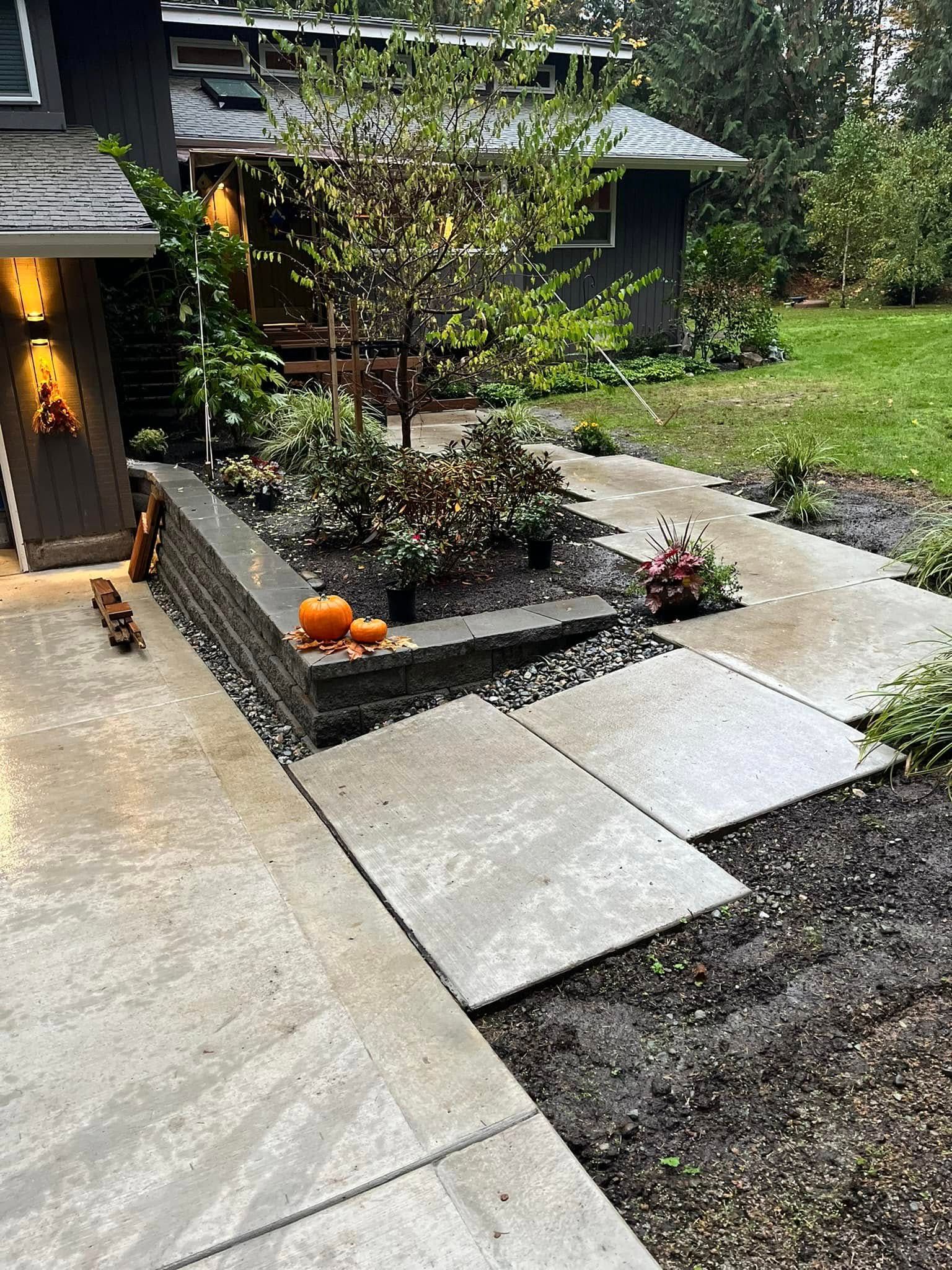 A concrete walkway leading to a house with pumpkins on it.