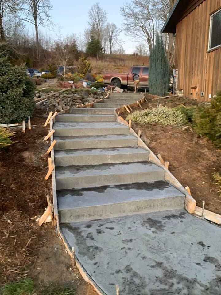 A concrete walkway is being built in front of a house.