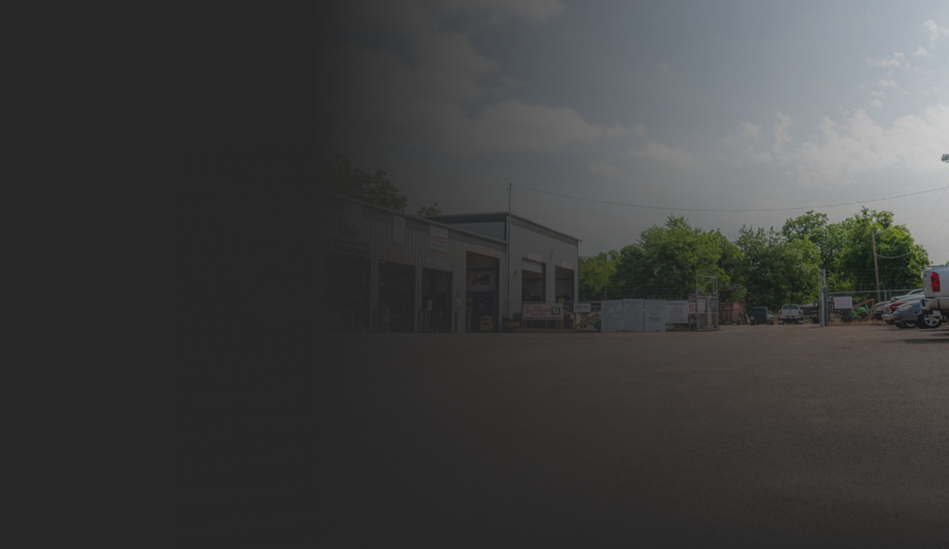Garage building with trees and cloudy sky | Rick's Automotive
