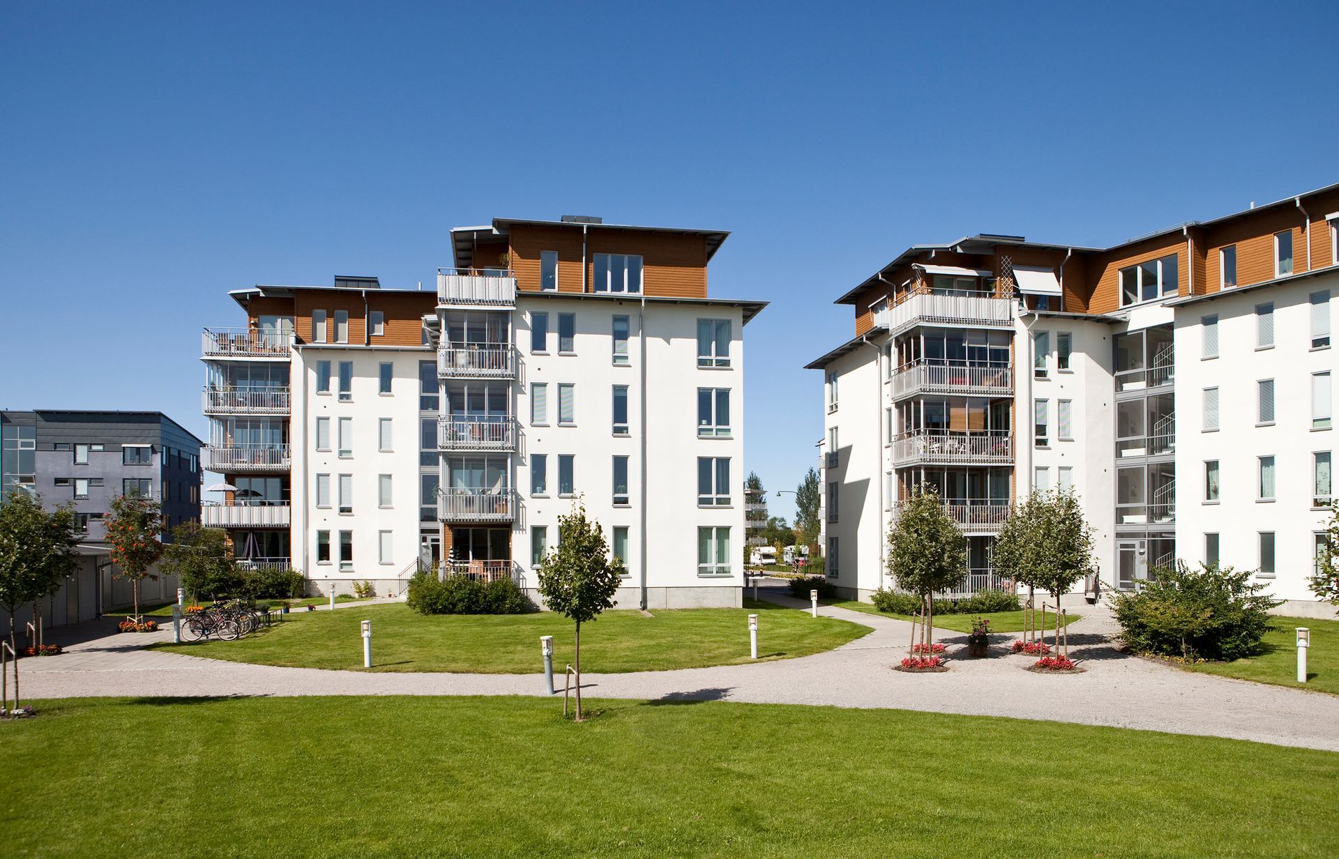 Edificios de apartamentos con fachadas blancas, balcones y tejados marrones