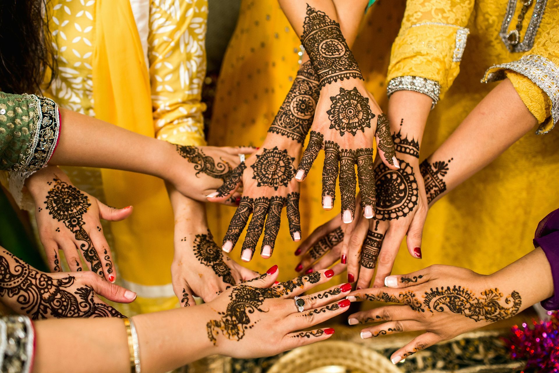 Indian women with mehndi henna hands celebrating — NRI ghar wapas UK to India moving service by The