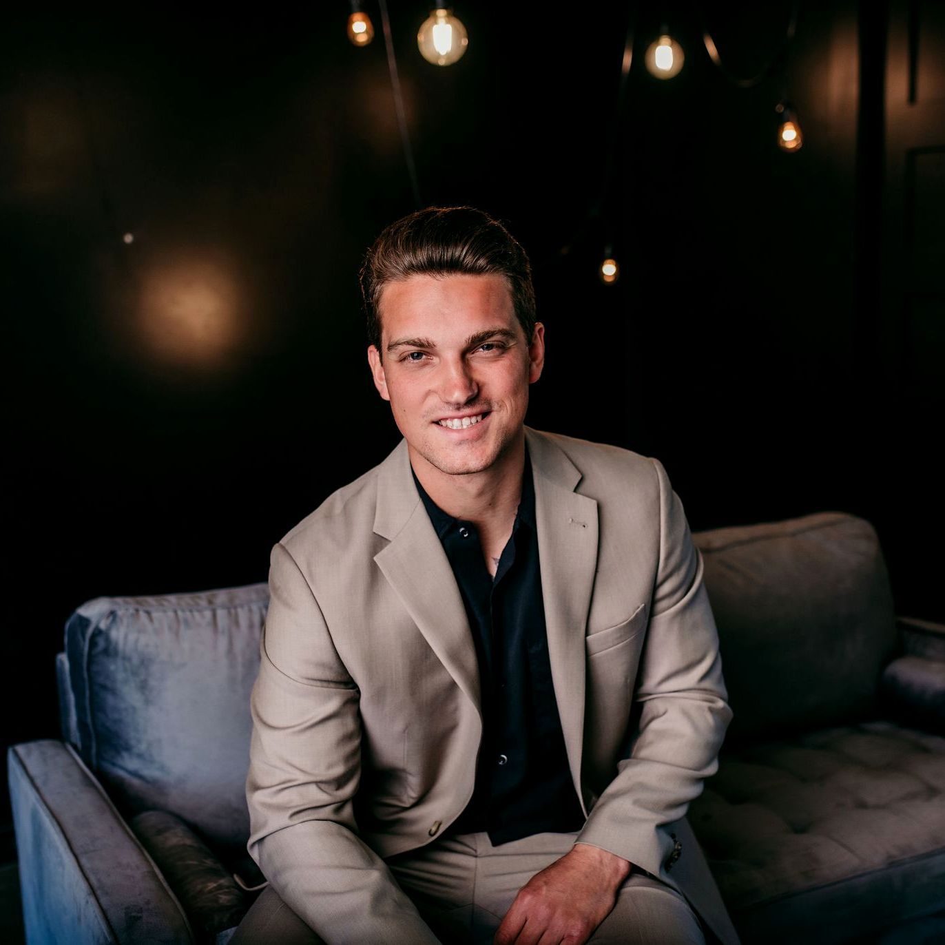 A man in a suit is sitting on a couch.