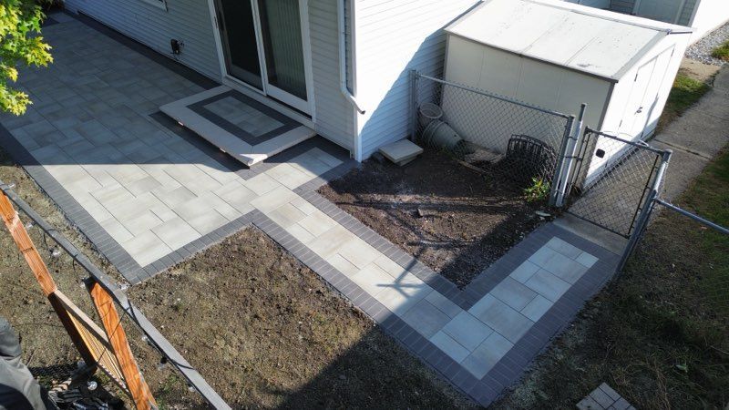 Back patio with modern furniture, steps, and glass doors reflecting bedroom; sunset colors.