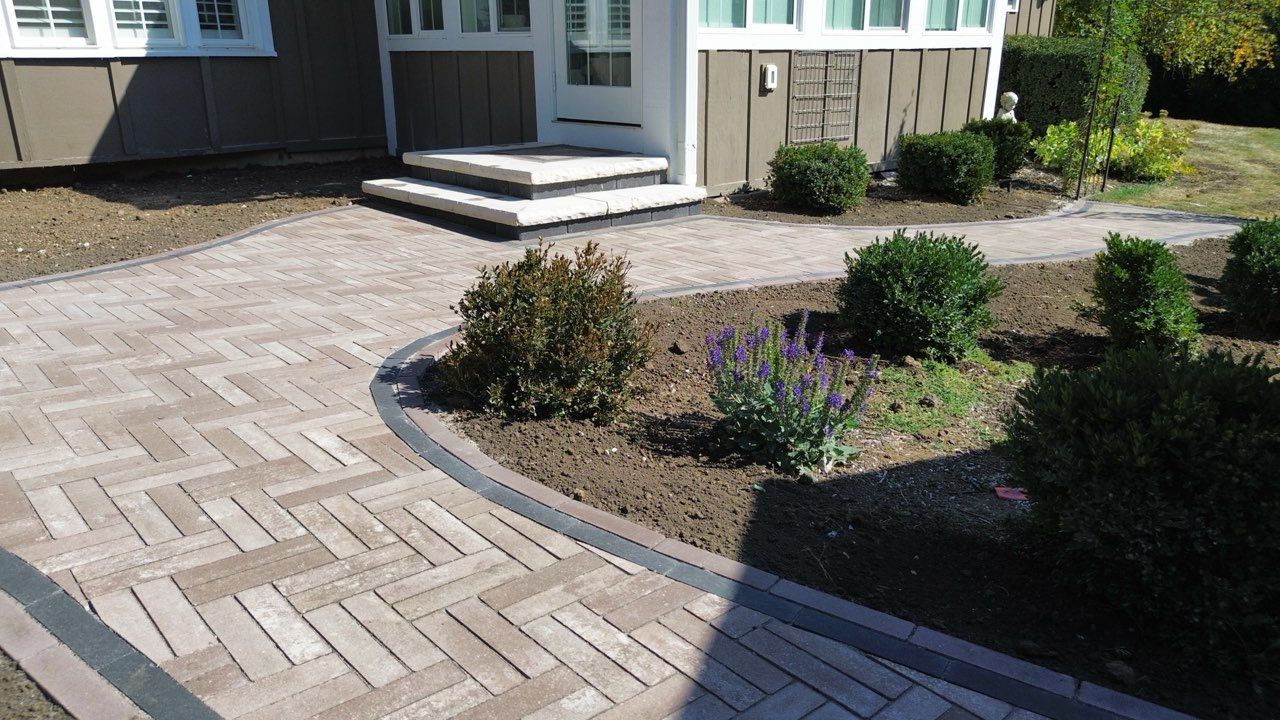Covered patio with wooden ceiling, concrete floor, fire pit, and wooden fence in background.