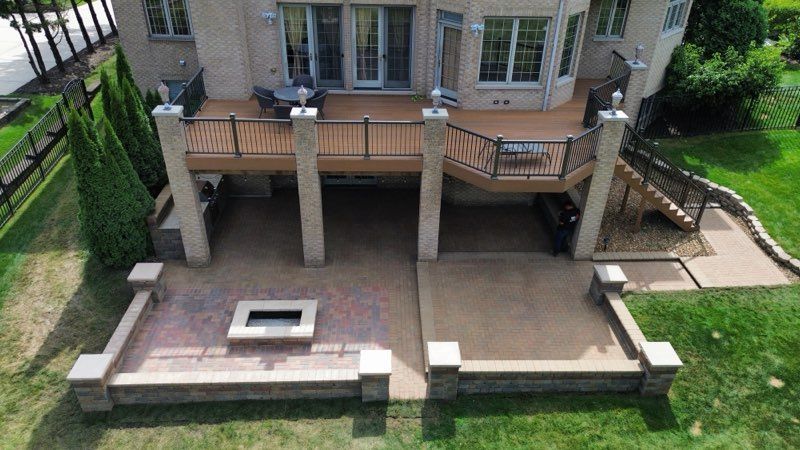 Pergola over a brick patio with seating, in a desert landscape.