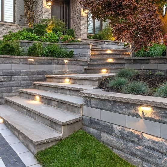 Stone pathway illuminated by small, evenly spaced lights at night.