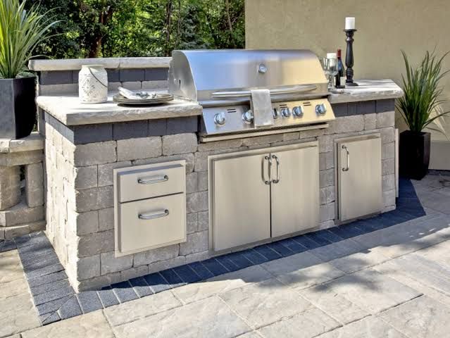 Outdoor kitchen with grill, sink, and countertop. 