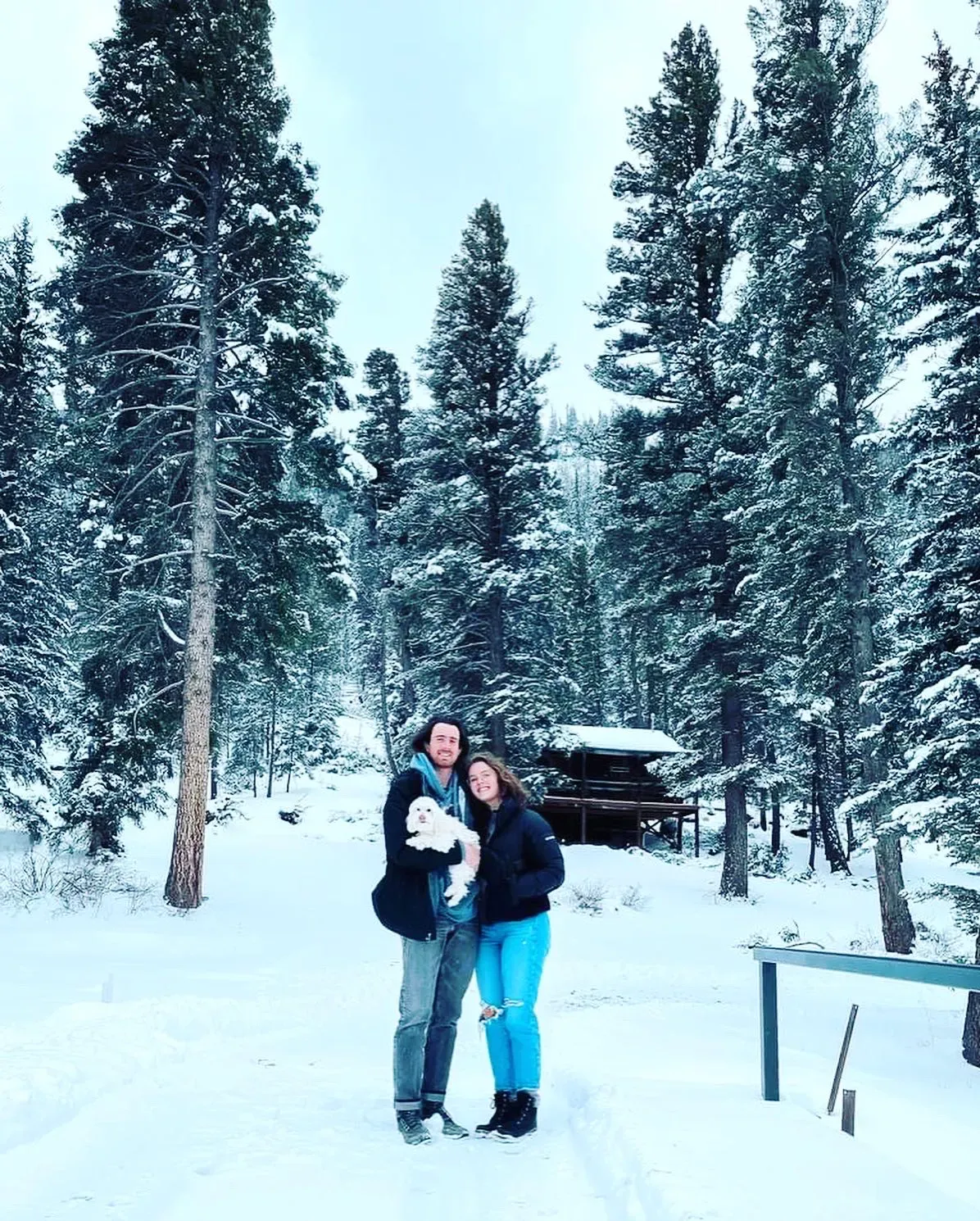 Couple in snow holding a dog