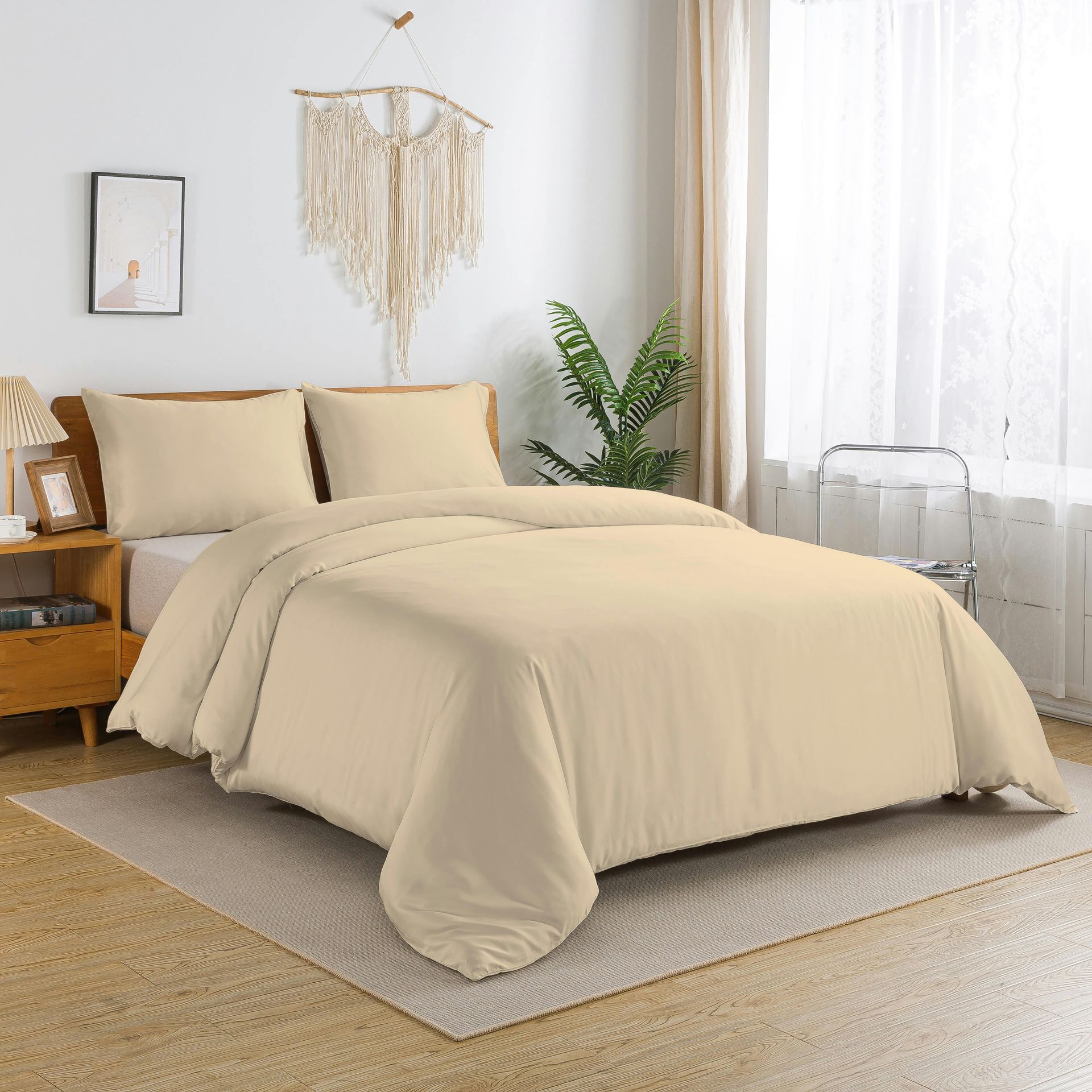 Beige bedding on a bed, with two pillows, in a bedroom with decor.
