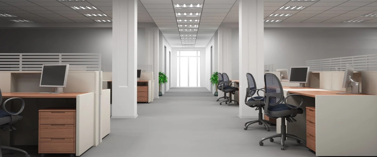 An office hallway with workstations, computers, and chairs.