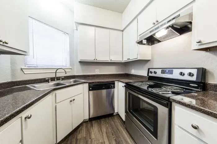 Three Villas - kitchen with grey laminate wood flooring and stainless steel appliances.