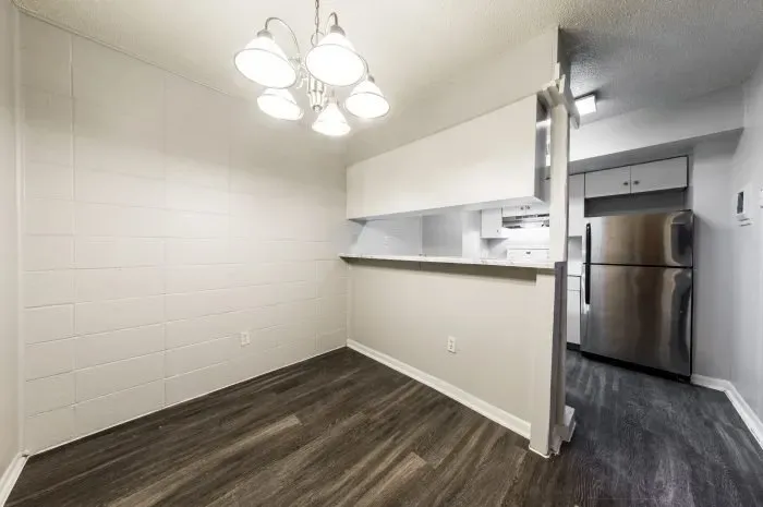 The Colony -  dining area with grey laminate wood flooring  looking into kitchen.