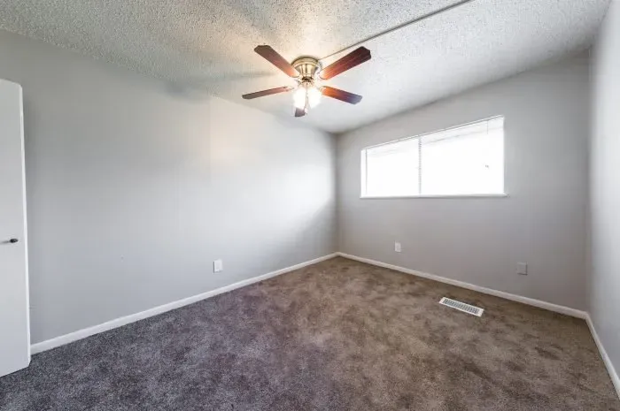 The Colony - bedroom with carpet and ceiling fan