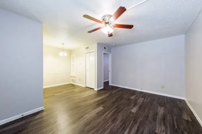The Colony - living room with grey laminate wood flooring  with ceiling fan