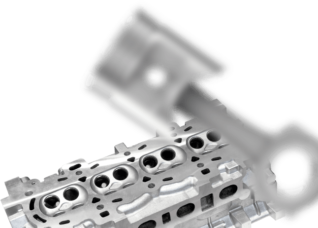 Engine cylinder head with piston in blurred background. | Louis Garage, Inc.