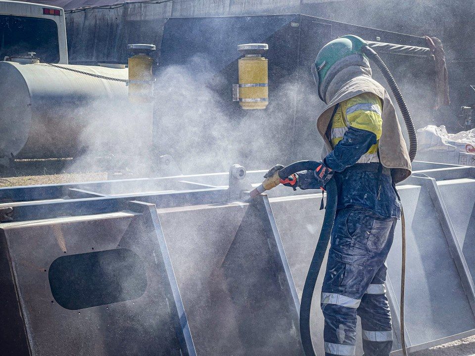 A Man Wearing a Helmet is Sandblasting a Metal Structure — Goat Collective in Grafton, NSW