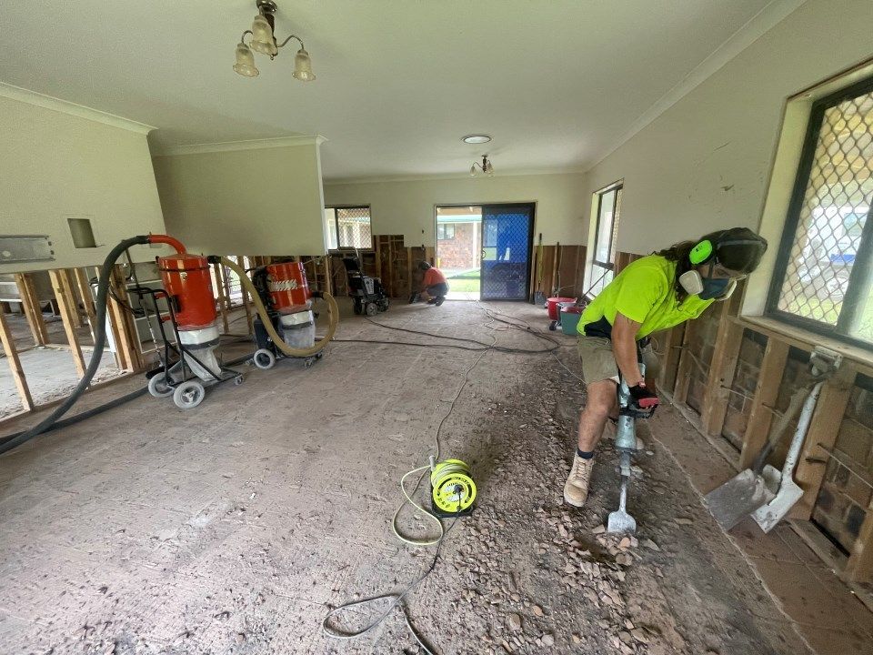 A Man is Working on the Floor of a House With a Drill — Goat Collective in Tintenbar, NSW