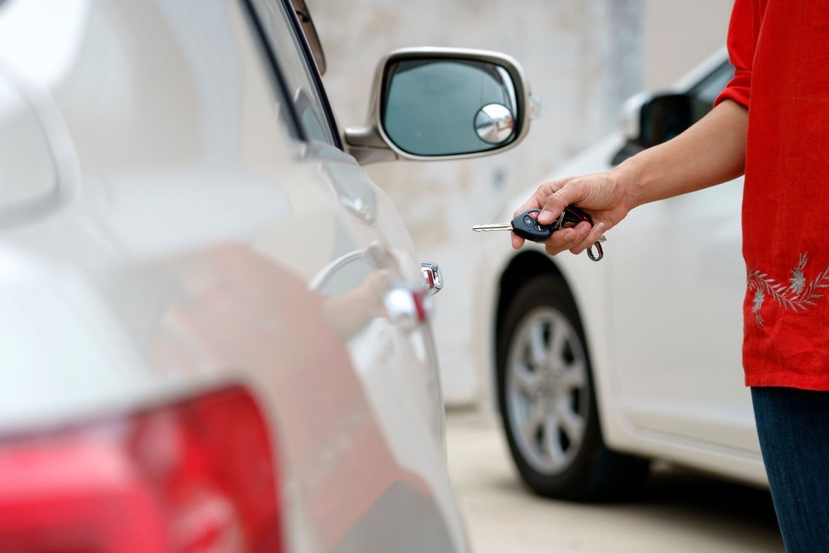 Person Unlocking White Car With Key Fob Outdoors — Albury Super Cheap Car Rentals in Jindera, NSW