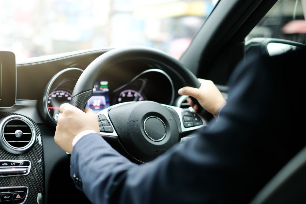 Hands Gripping a Black Steering Wheel Inside a Car, Dashboard Visible — Albury Super Cheap Car Rentals in Lavington, NSW