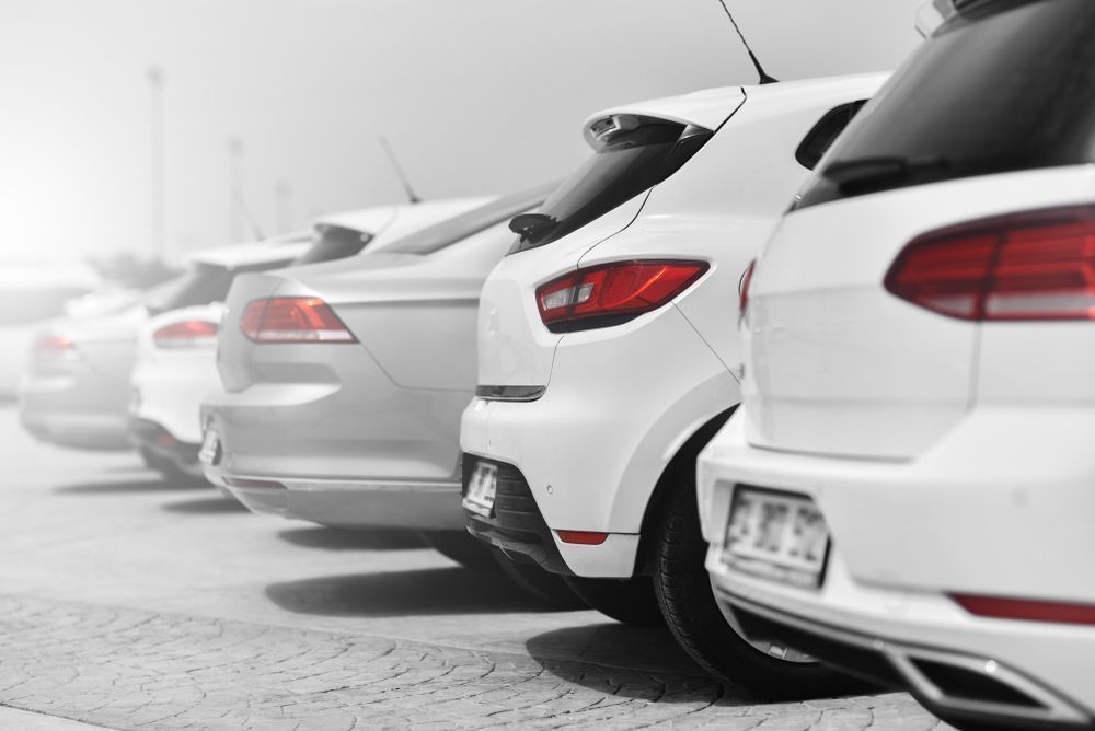 Row of Parked Cars, Mostly White, With Tail Lights Visible — Albury Super Cheap Car Rentals in Lavington, NSW