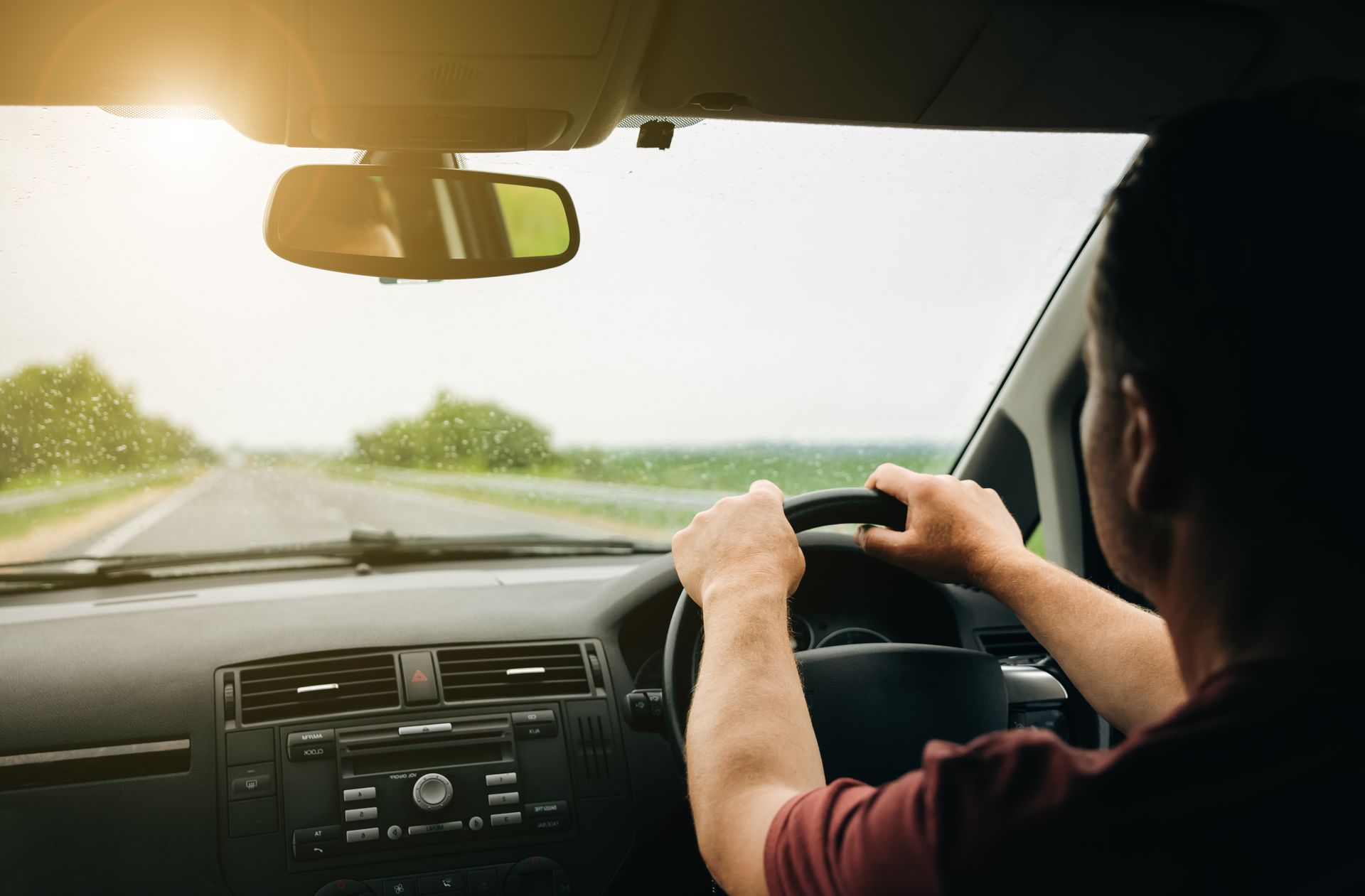 Person Driving a Car, Hands on the Steering Wheel, Looking at a Road Ahead — Albury Super Cheap Car Rentals in Lavington, NSW