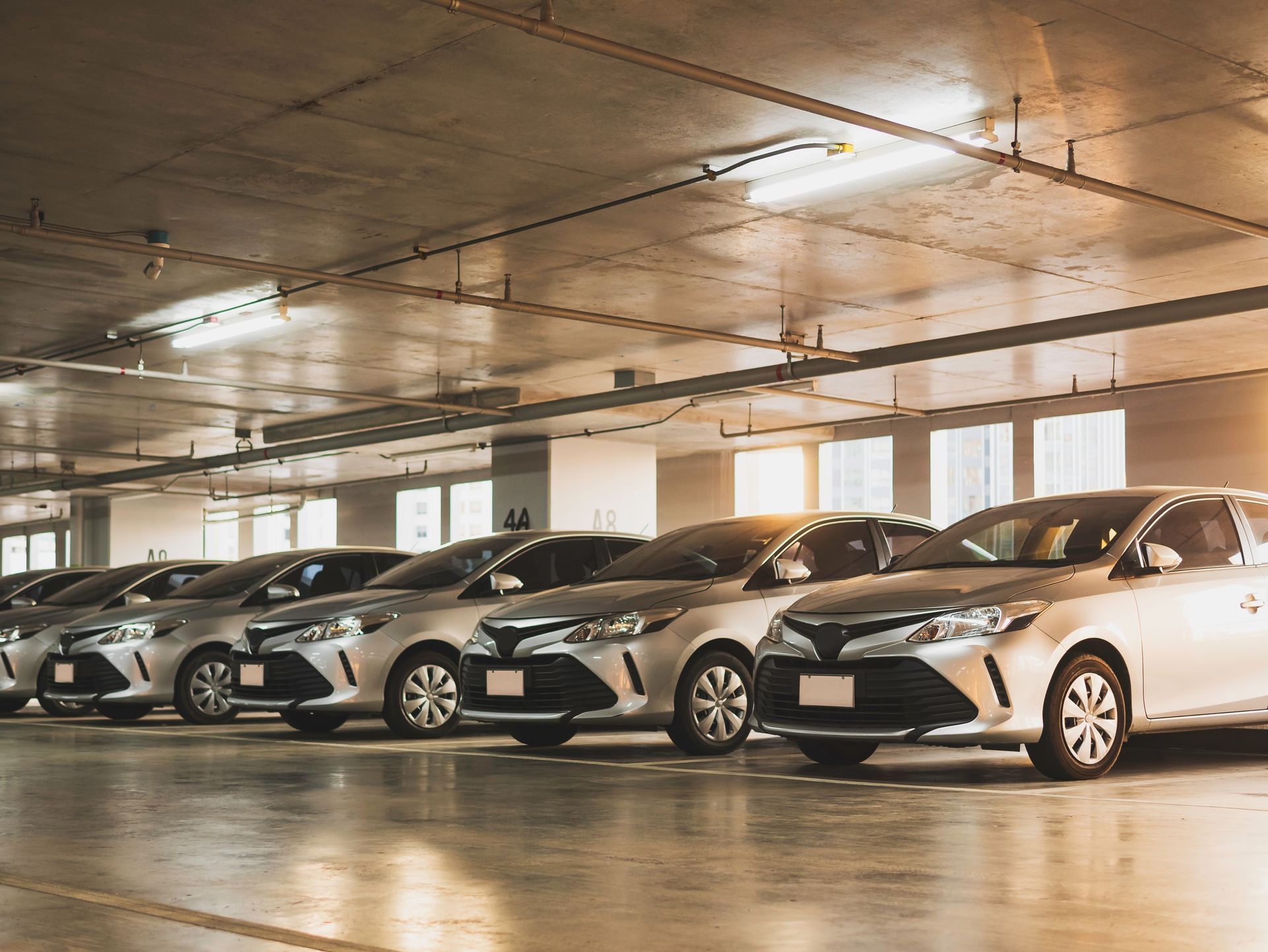 Line of Silver Cars Parked in an Indoor Parking Garage — Albury Super Cheap Car Rentals in Lavington, NSW