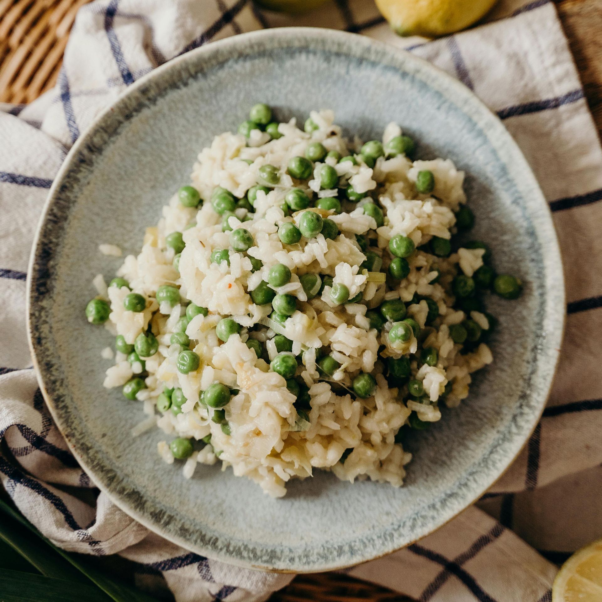 A bowl of haddock risotto and peas on a table.