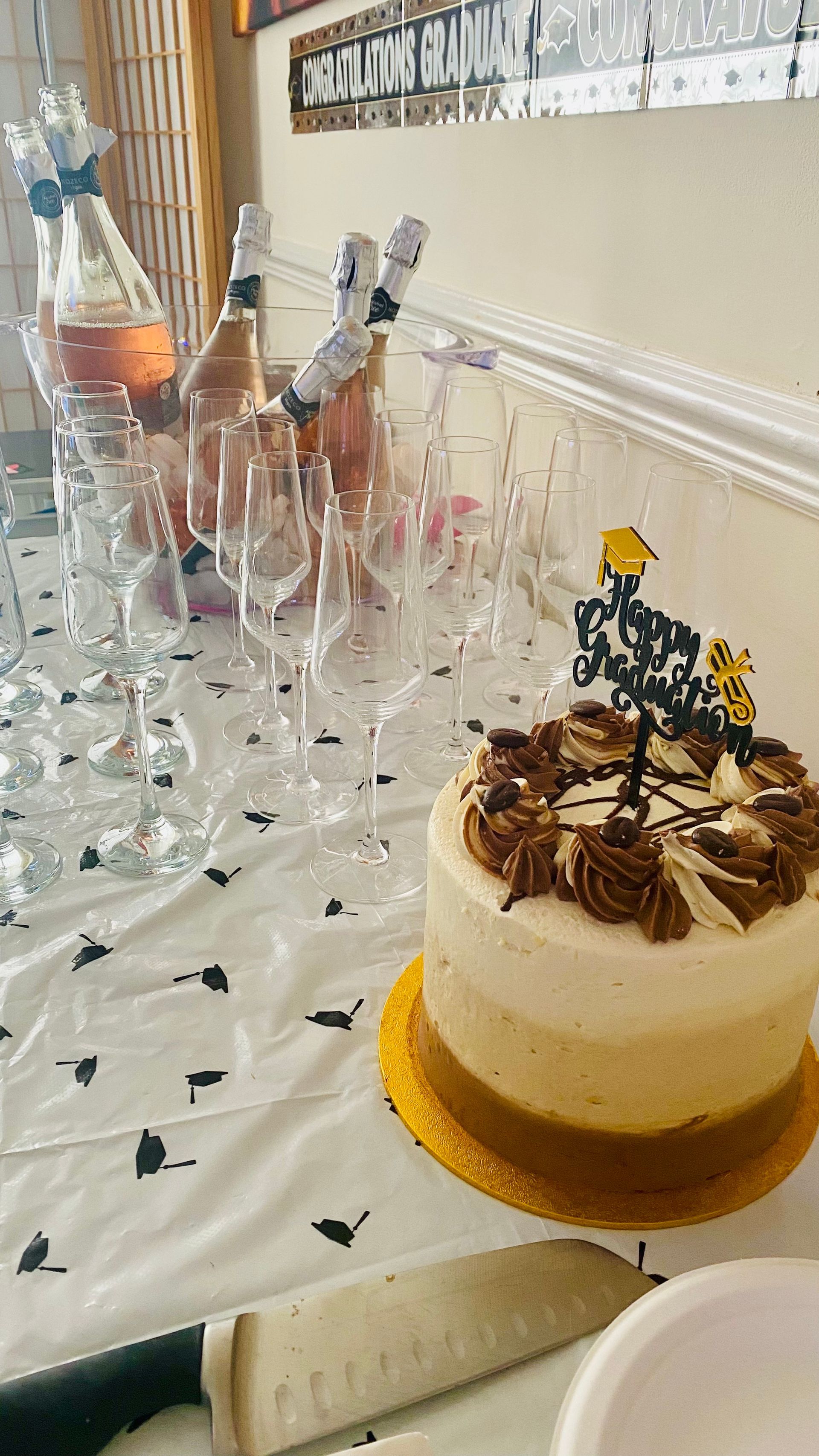 Cake, champagne, and glasses on a decorated table, celebrating an event.