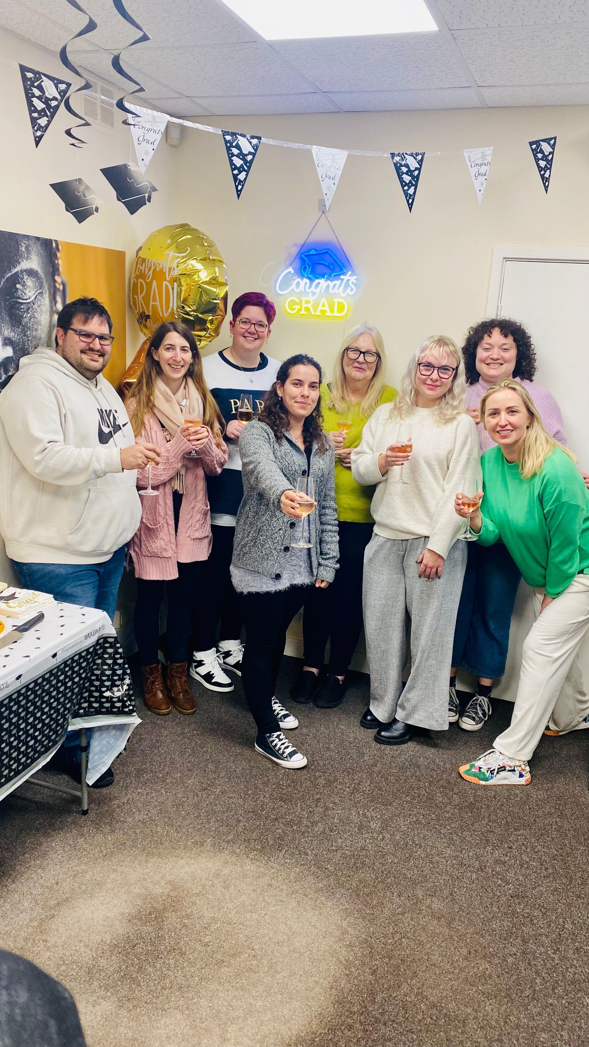 Group of people celebrating with champagne, decorated room.