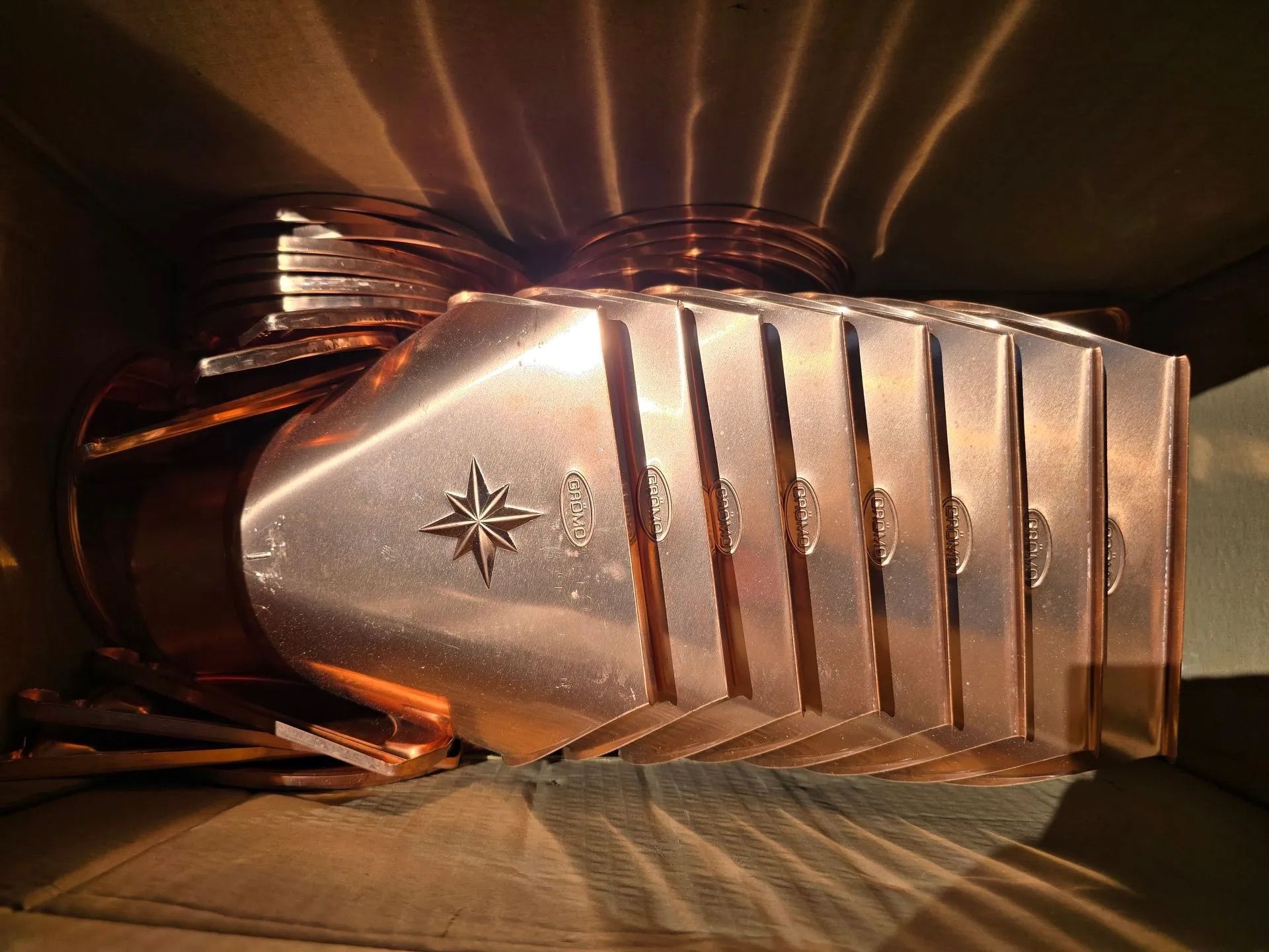 Close-up of a metallic silver comb with black teeth and a star emblem on a dark surface