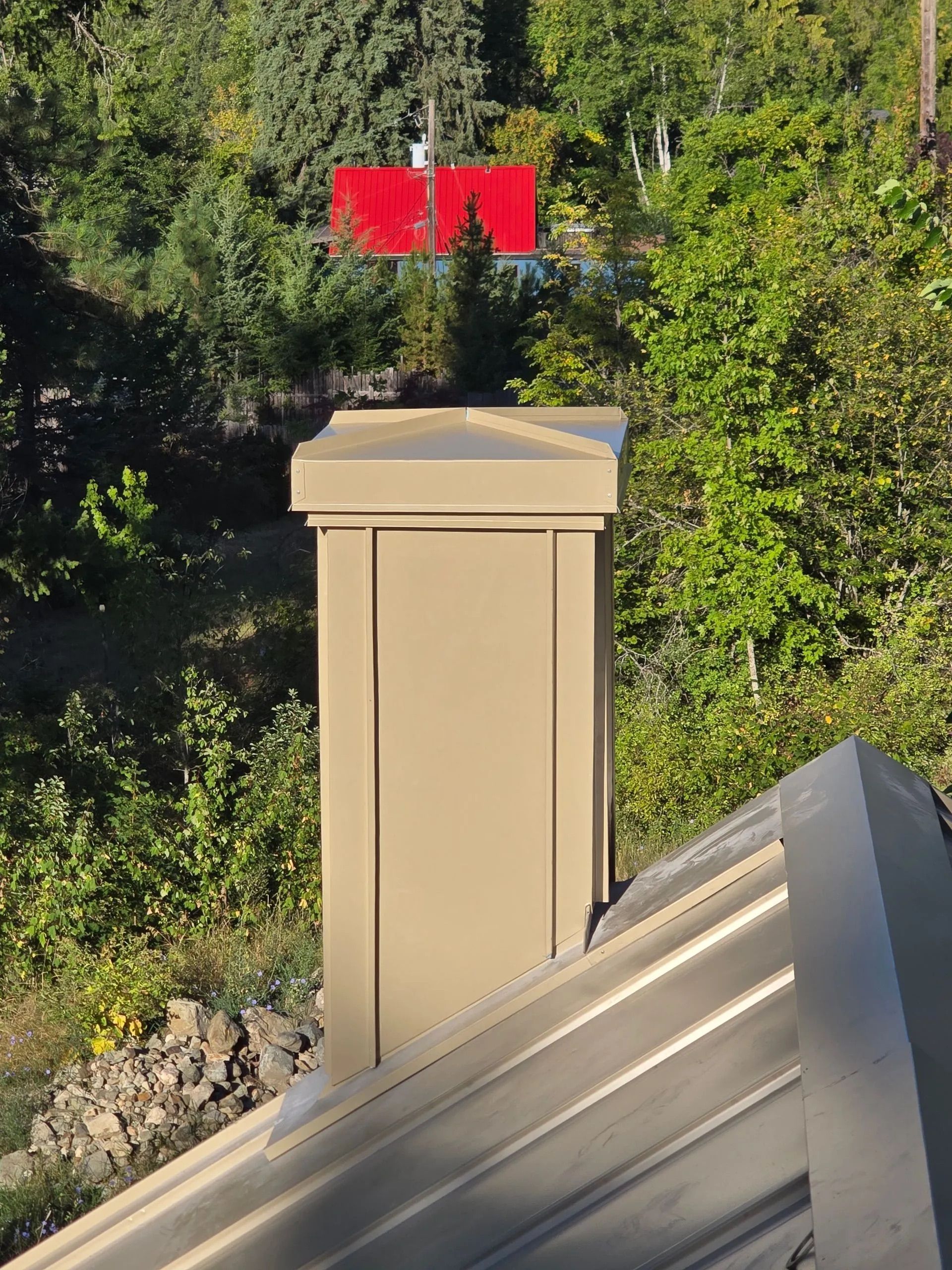 Beige post in a green yard with a bright red flag in the background