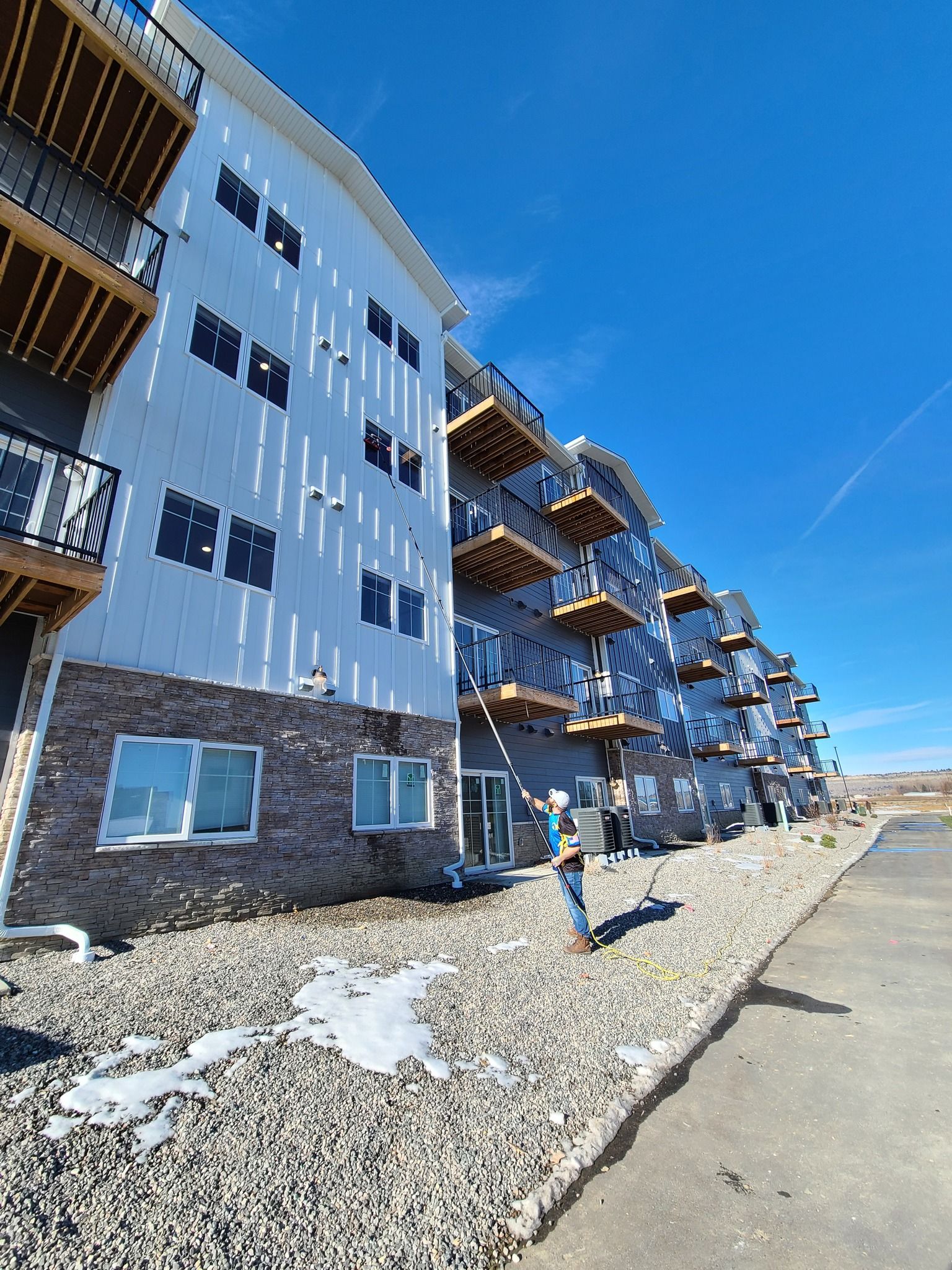 A large apartment building under construction with a blue sky in the background
