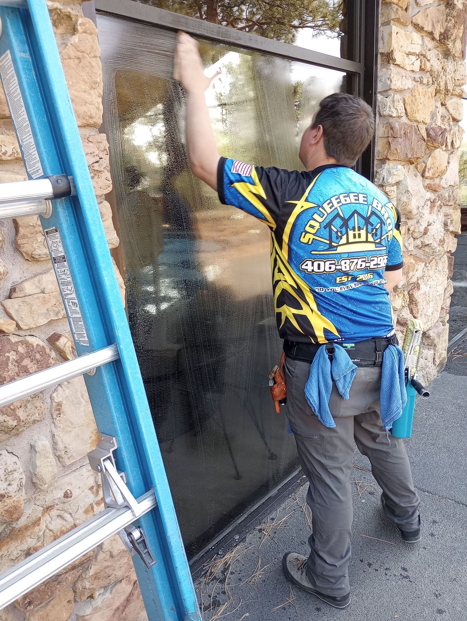 A man is cleaning a window with a ladder.