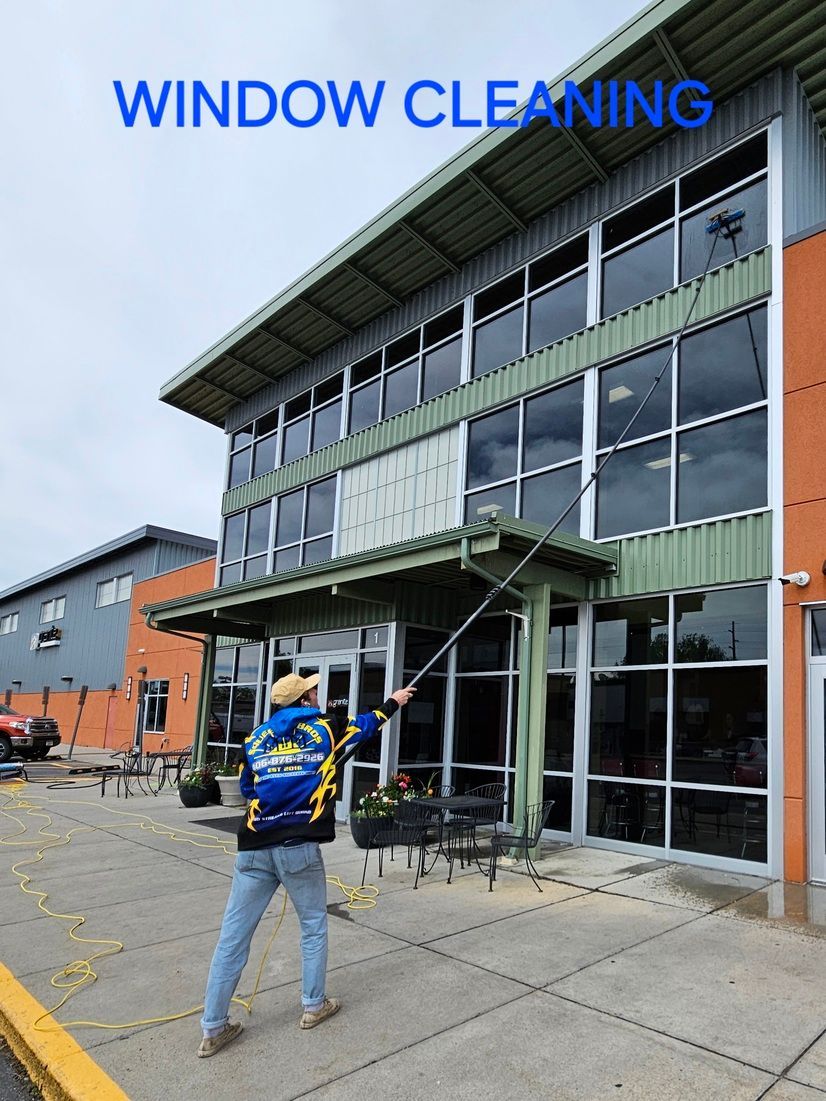 A man is cleaning the windows of a large building.