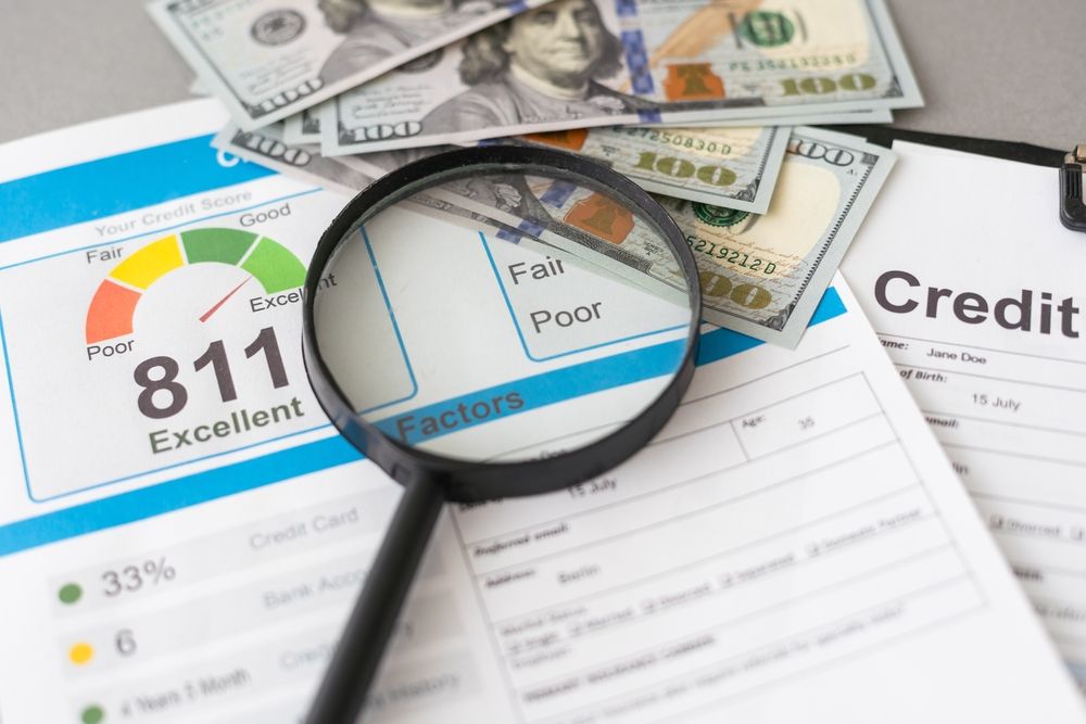 Magnifying glass on a credit report showing an excellent score, with money in the background.