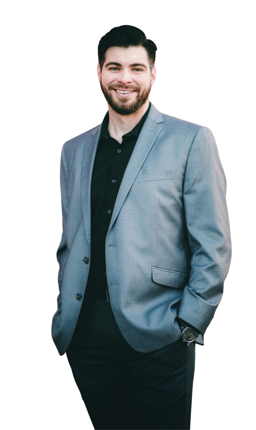 a man in a suit and black shirt stands with his hands in his pockets