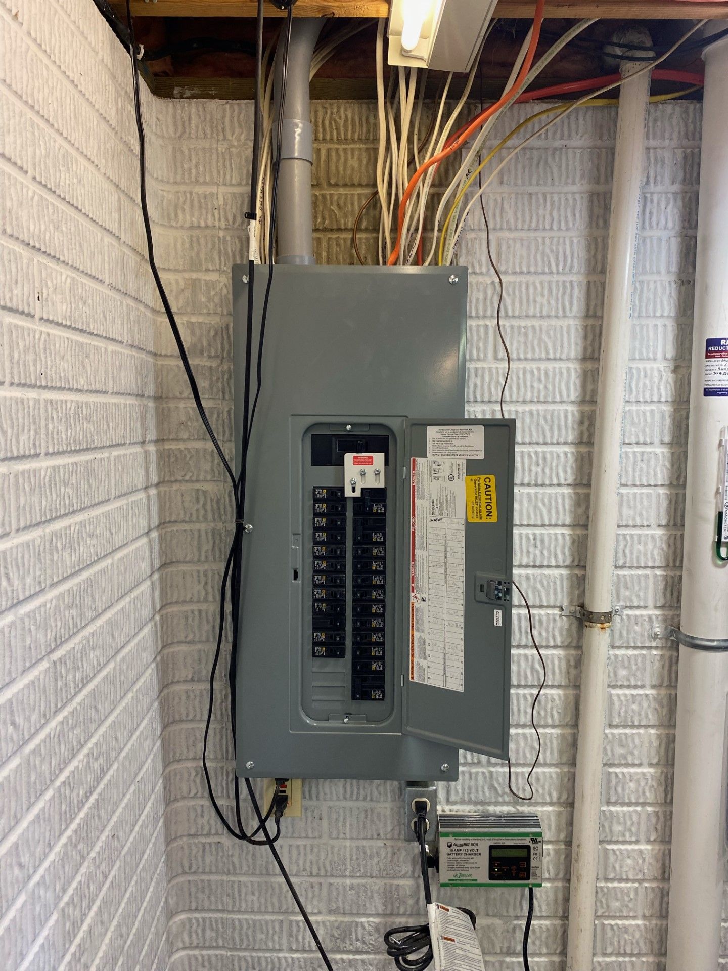 An electrician is working on a electrical panel with a multimeter.