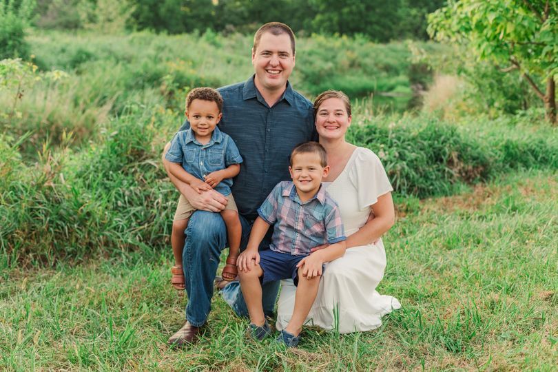 A family is posing for a picture in a field.