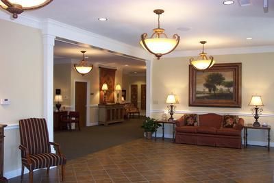 A living room with a red couch and chairs
